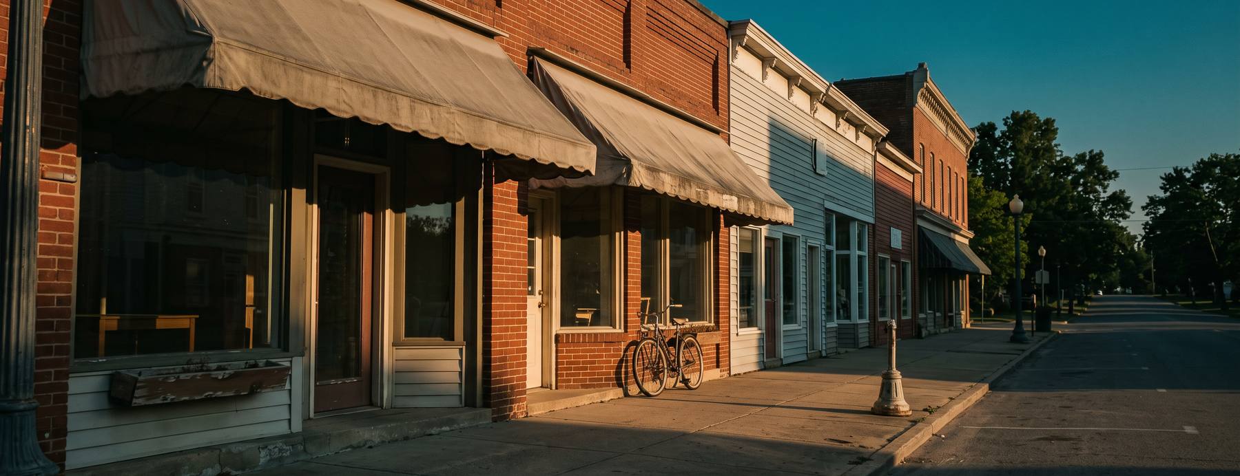 A row of small independent main street storefronts at golden hour